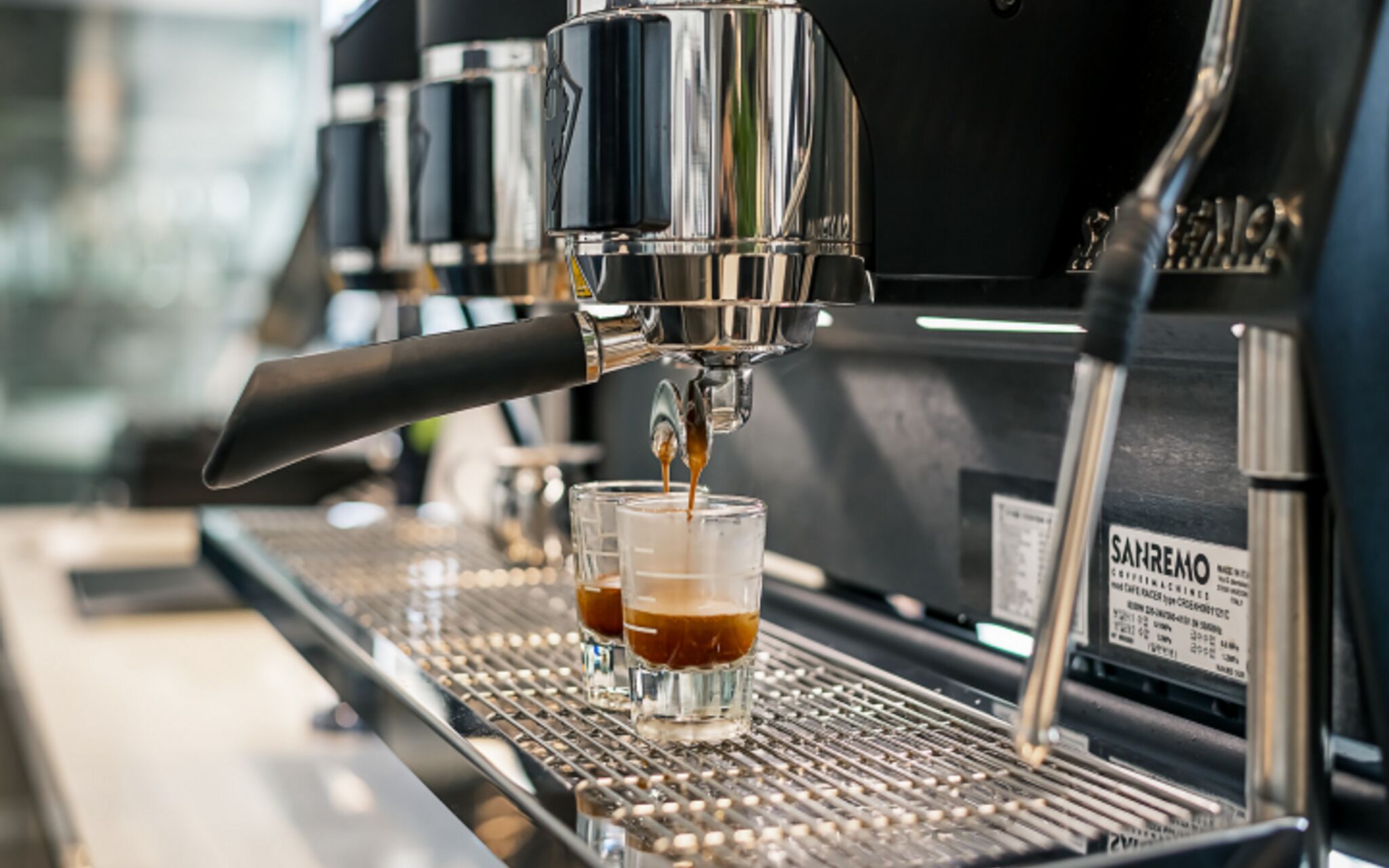 Una macchina per espresso con due tazze di caffè in preparazione.