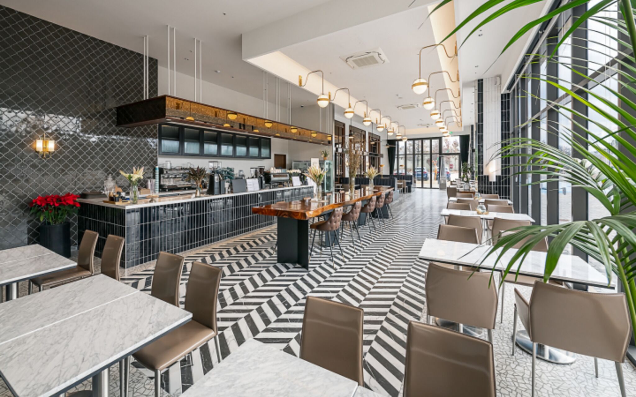 A modern restaurant with a central bar, high ceilings, and a patterned floor.