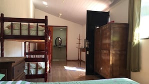 A room with a bunk bed, a wooden wardrobe, a desk, and a chair. - JP Estudio (RJ)