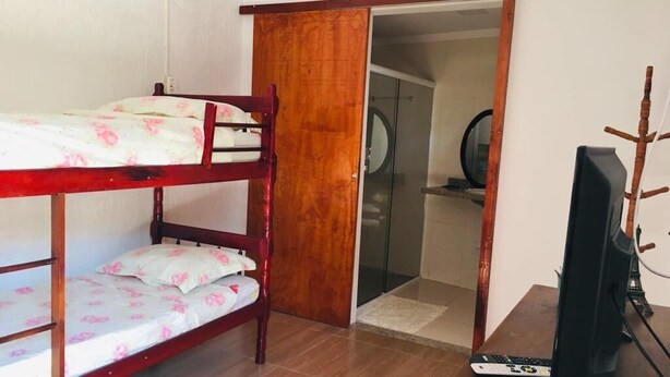 A room with a bunk bed, a desk with a computer, and a mirror. - JP Estudio (RJ)