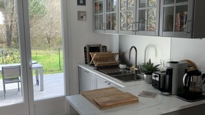 Una cocina moderna con una isla grande, electrodomésticos de acero inoxidable y vistas al exterior.