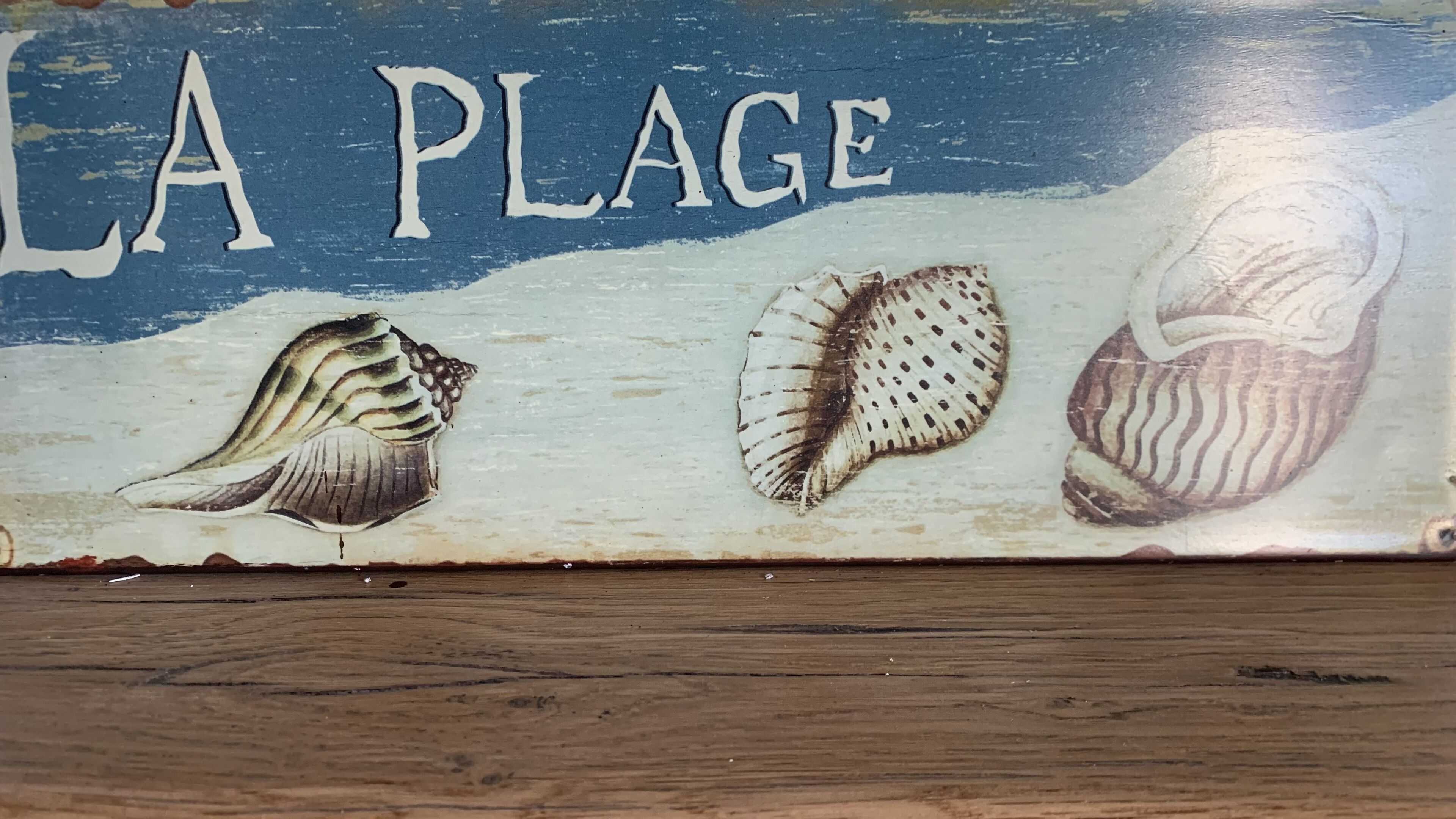 Un senyal de fusta amb el text "LA PLAGE" i tres síndries.