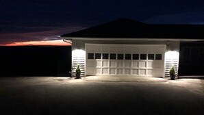 A garage with a white door, two potted plants, and a driveway. - Mountain View Getaway (West Cornwall)