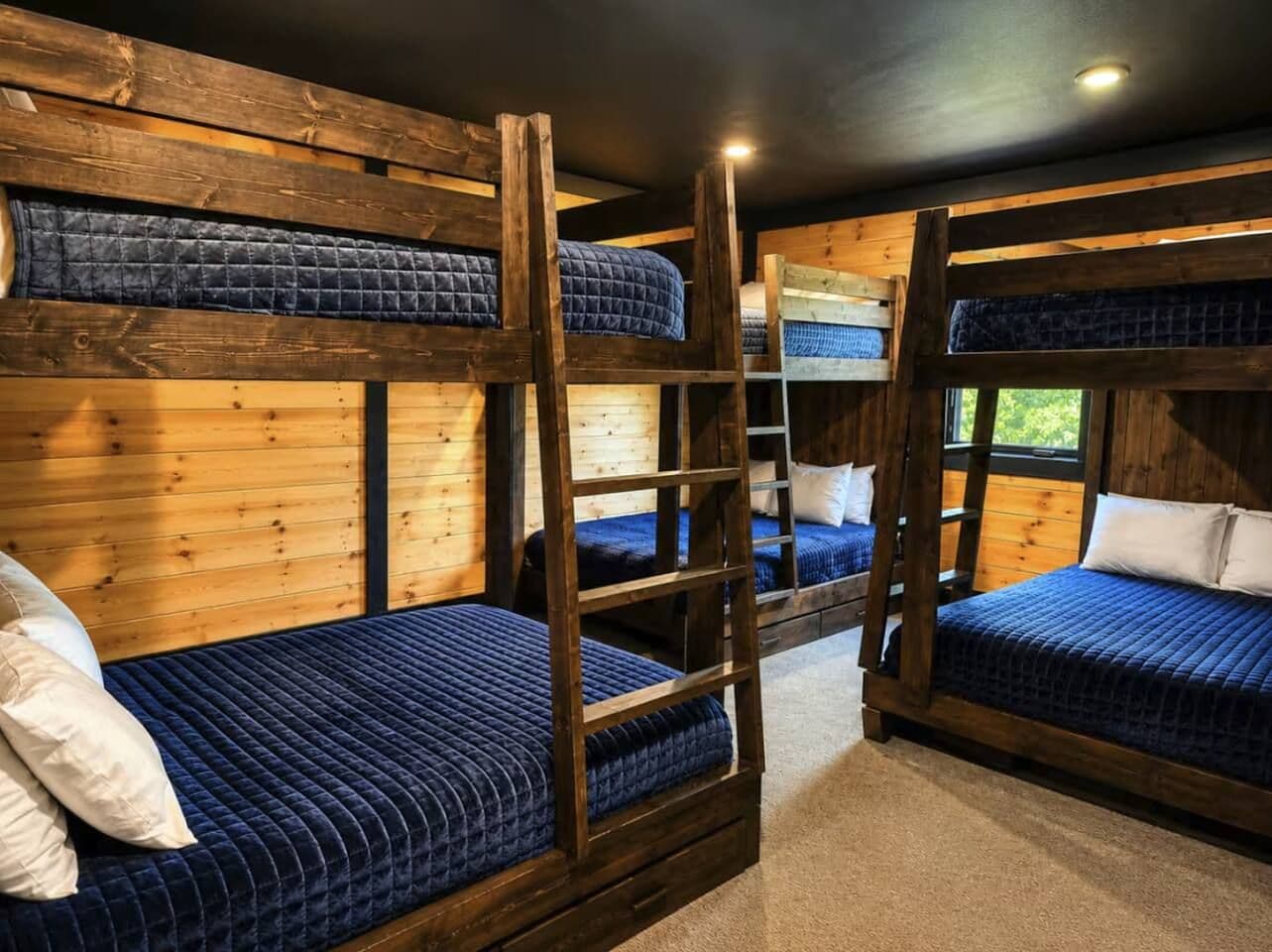A bunk bed room with wooden walls and a ladder.