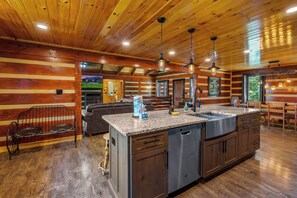 A spacious kitchen with a granite countertop, stainless steel appliances, and wooden cabinetry.