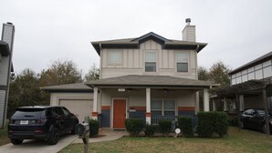 A two-story house with a front porch, a garage, and a driveway. - The Establishment (Atl)