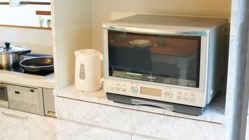 Una cocina equipada con microondas, hervidor y estufa.