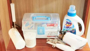 A storage box with various cleaning supplies, a bottle of disinfectant, a hairdryer, and a set of keys.