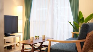A living room with a television, a coffee table, two mugs, and a chair. - Ryoushi Minpaku CHOUTA (Awaji)