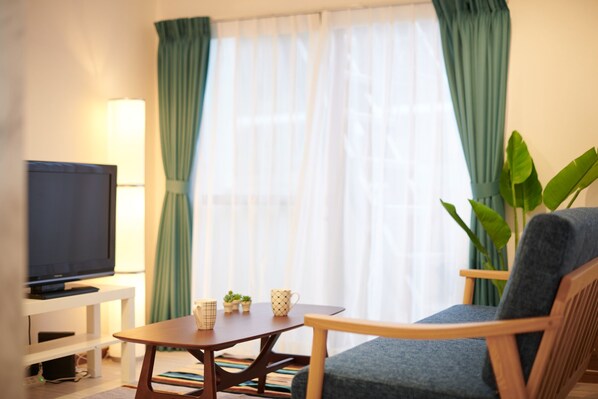 A living room with a television, a coffee table, two mugs, and a chair. - Ryoushi Minpaku CHOUTA (Awaji)