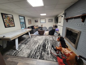 Um quarto acolhedor com uma mesa comprida, lareira e um cavalinho de baloiço.