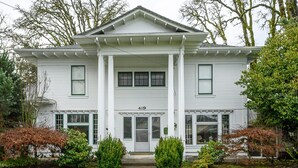 A two-story white house with a central entrance, numbered 419, surrounded by well-maintained shrubbery and trees. - Beautiful Wine Country Escape (Carlton)