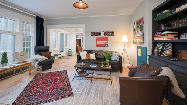 A living room with a fireplace, a coffee table, a sofa, and a bookshelf. - Beautiful Wine Country Escape (Carlton)