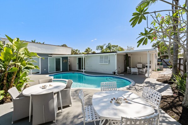 A backyard with a swimming pool, outdoor furniture, and a house. - Beautiful Downtown Naples Close to All Naples Has to Offer (Naples)