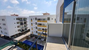 Un immeuble d’appartements moderne doté de balcons, d’une piscine et d’une façade en verre.