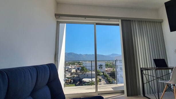 Un balcon offrant une vue sur la ville et les montagnes.