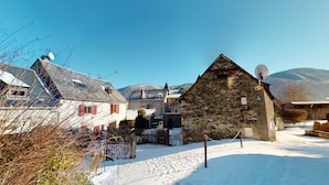 Un pueblo cubierto de nieve con edificios de piedra tradicionales y un cielo azul despejado.