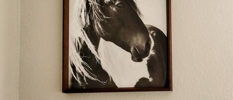 A framed black and white horse portrait on a wall.