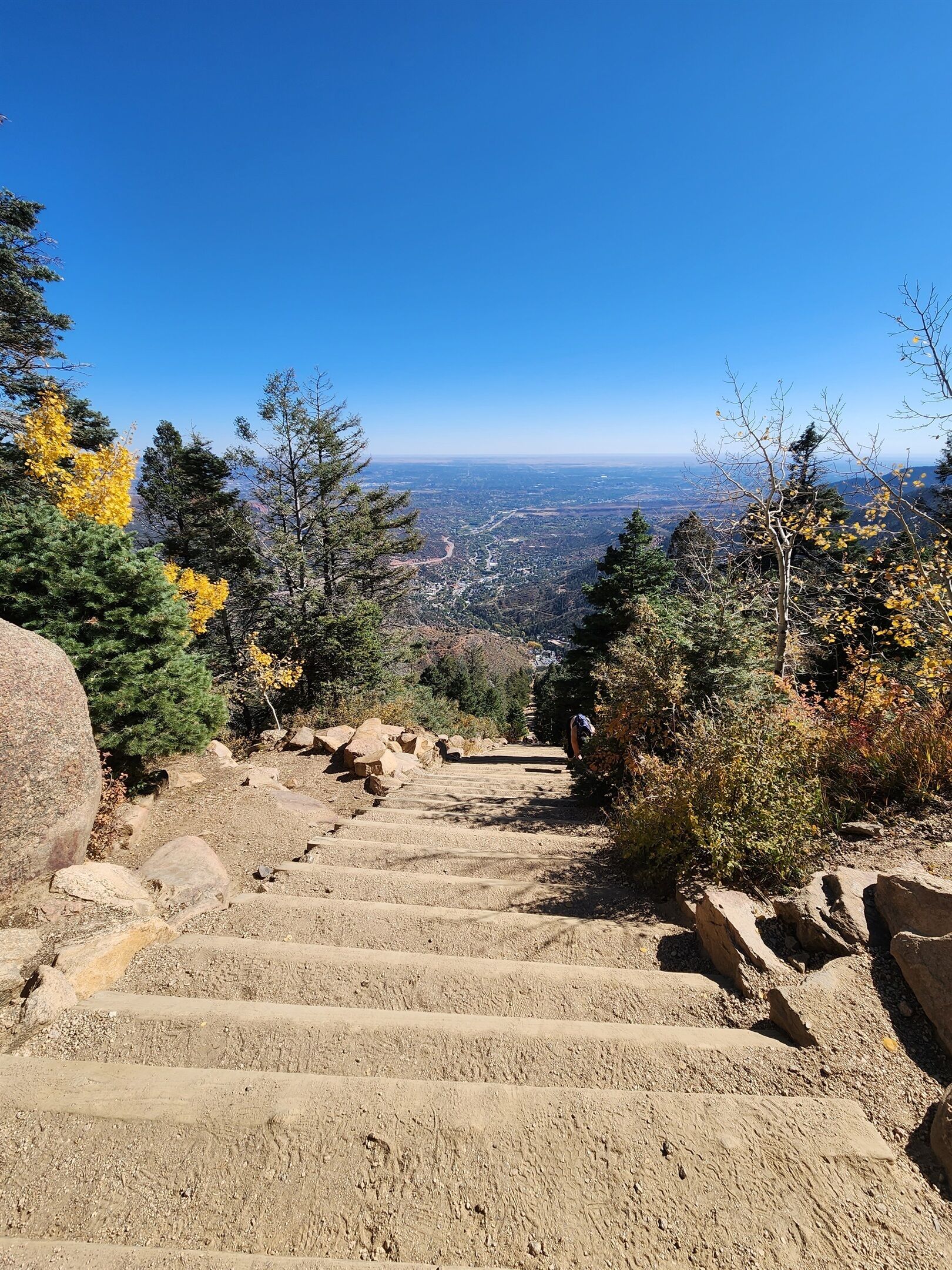 A set of stone steps leading up a mountain with a clear view of a valley below.