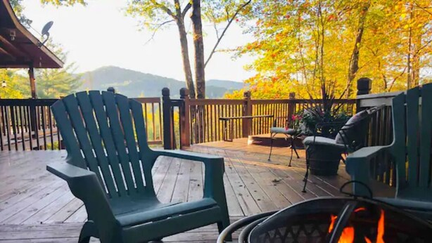 A wooden deck with a fire pit and outdoor seating. - Private pet-friendly Aska Adventure Area getaway with gorgeous views! (Blue Ridge)