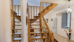A wooden staircase with multiple landings leading to a second floor. - Hydra's Pearl - Blue Pearl (Hydra)