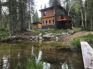 Escape to a serene forest retreat, surrounded by trees and a tranquil pond.