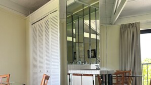 A modern kitchen with a glass top table, wooden chairs, and a view of the outdoors. - KG Arrive any day, pool on beach, full Kitchen, W/D, Parking, Docks, balcony,  (Marathon)