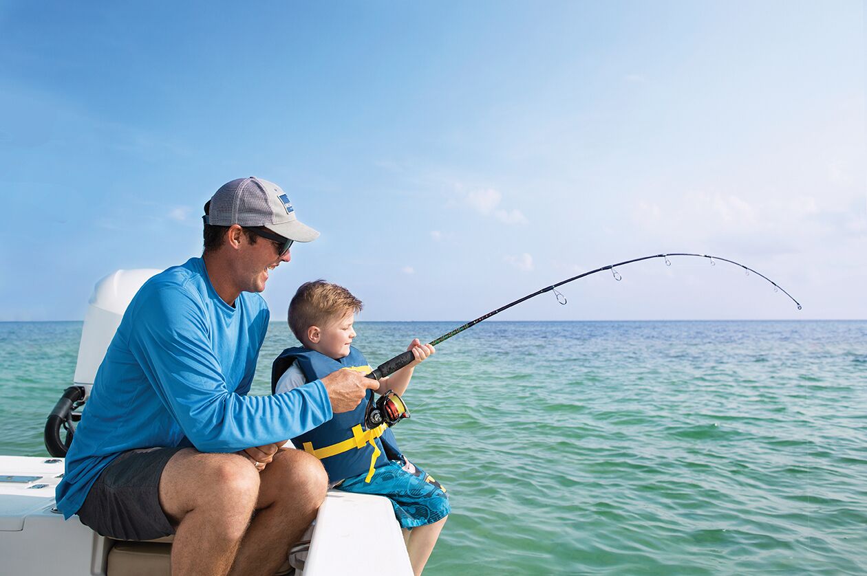 Two people on a boat, one holding a fishing rod.