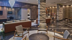 A modern lobby with a reception desk, seating area, and a chandelier. - TIME BUILDING - BEST LOCATION IN THE CITY (maceio)