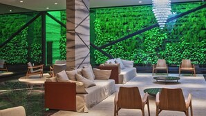 A modern lobby with a green wall, seating area, and a chandelier. - TIME BUILDING - BEST LOCATION IN THE CITY (maceio)