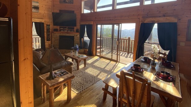 A spacious wooden cabin with a fireplace, a TV mounted on the wall, and a balcony with a scenic mountain view. - Spectacular Mountain View is Yours to Enjoy (Sevierville)