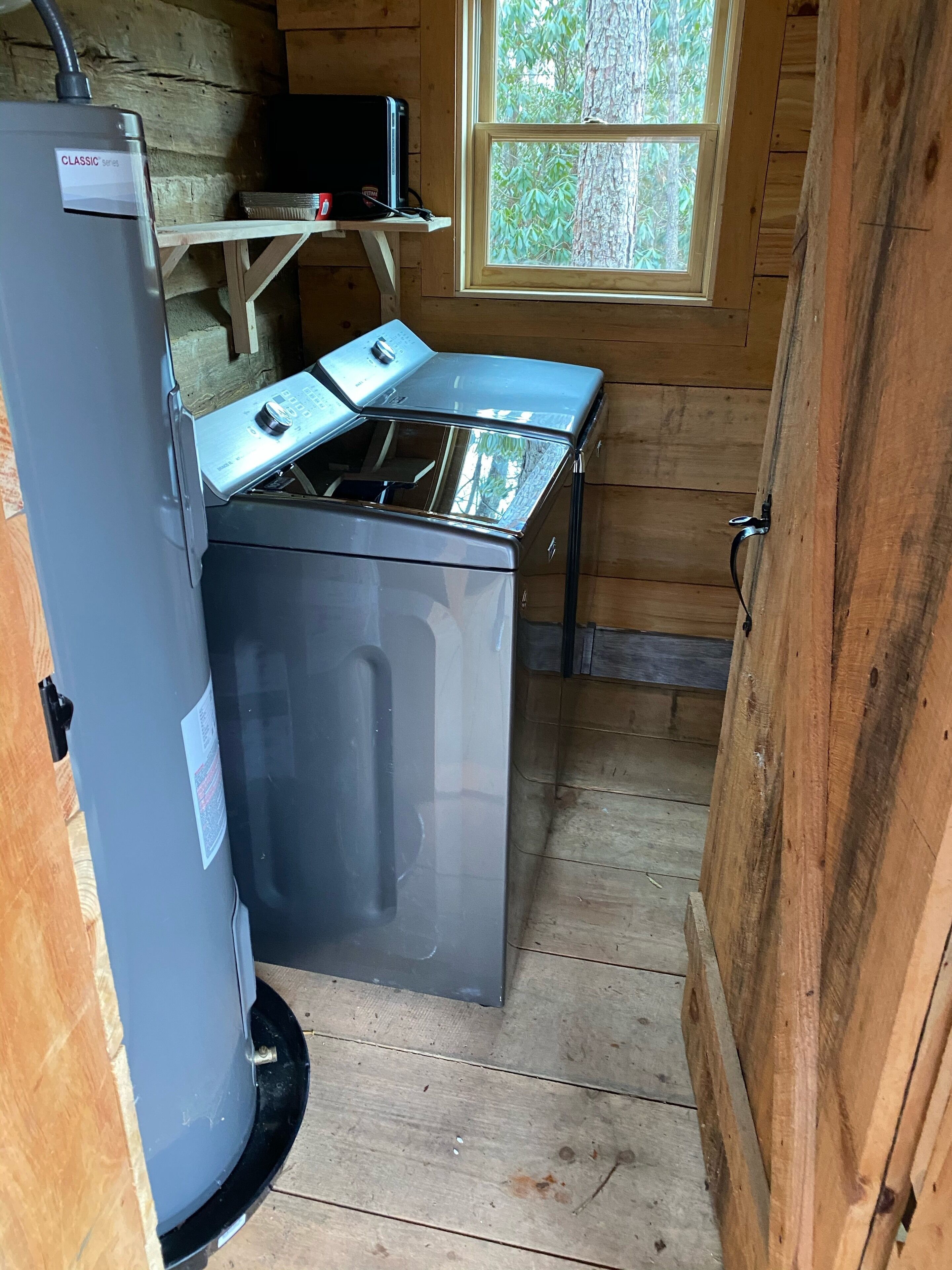 A compact kitchen with a built-in stove, a small refrigerator, and a window providing natural light.