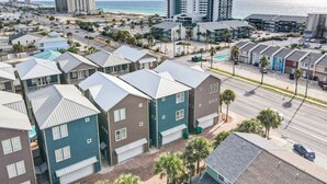 Zona residencial costera con edificios modernos de varios pisos, una playa y cielo despejado.