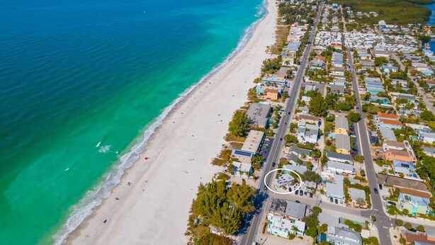 An aerial view of a coastal town with a beach, residential buildings, and a road. - Low Rider - Bottom Unit -  (Bradenton Beach)