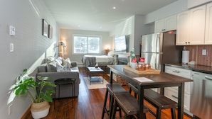 A compact living space with a kitchenette, a dining area, and a seating area with a sofa and a coffee table.