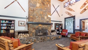 A cozy interior with a stone fireplace, bookshelves, and comfortable seating.