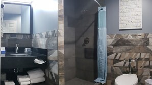 Un baño con diseño moderno, que incluye un lavamanos, inodoro y zona de ducha.