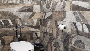 Un baño de diseño moderno, con inodoro, secamanos y cubo de basura.