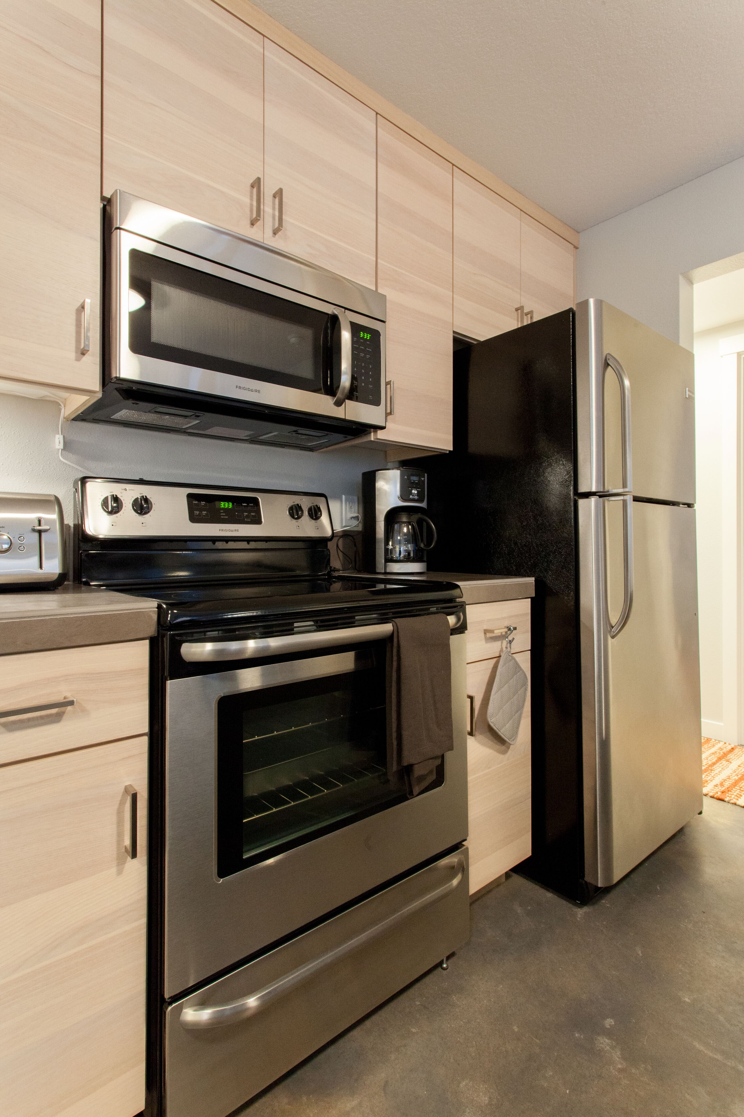 A modern kitchen with stainless steel appliances, including a microwave, oven, and refrigerator.