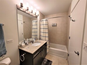 Une salle de bain avec un lavabo, un miroir et une douche.