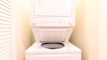 A front view of a white washing machine with control panel, open door, and a blue detergent dispenser.