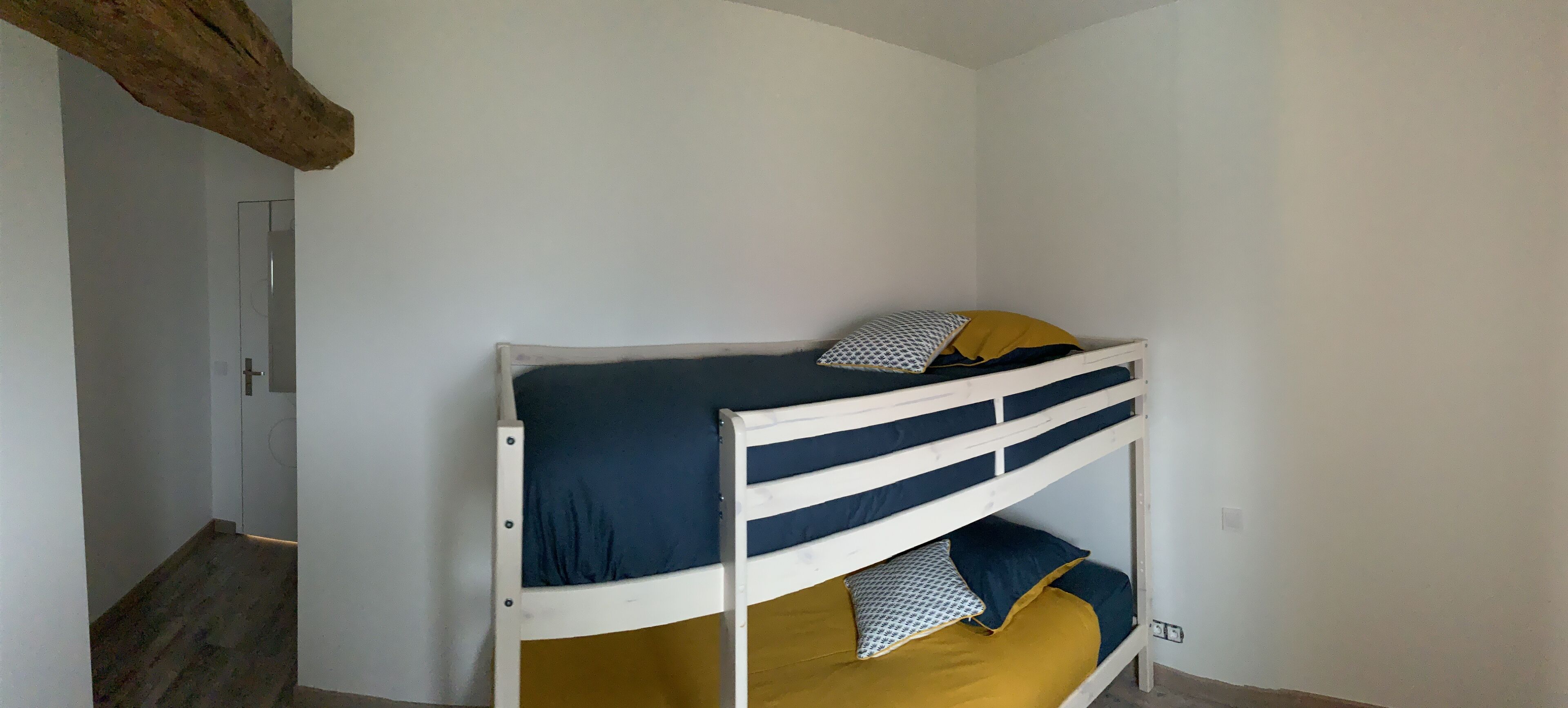 A bunk bed with two levels, each with a pillow and a blanket.