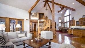 A spacious living room with a fireplace, a dining area, and a kitchen with wooden cabinets.