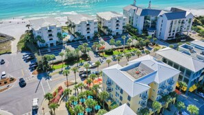 Ein Strandhotel mit mehreren Gebäuden, einem Parkplatz und einem Strand im Hintergrund.