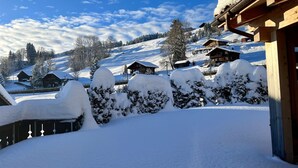 A snow-covered landscape with wooden buildings and a clear sky. - Apartment Ariel by Interhome (Saanenmöser)