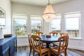 Enjoy meals in this dining area with a round table and six chairs, a sideboard, and a chandelier.