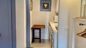 A narrow hallway with a wooden bench, a small table, and a hanging light fixture. - Portolano - Portolano 6 (Porto Azzurro)