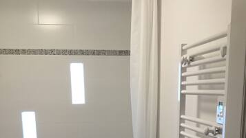 Bathtub, hair dryer, towels, toilet paper