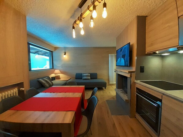 A modern kitchen with a built-in oven and a dining area with a red tablecloth. - Dream house four-leaf clover. (Folgarida)