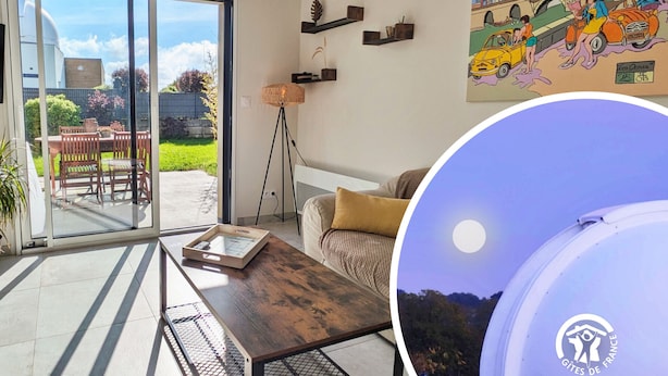 A modern living room with a sliding glass door leading to a patio, a wooden coffee table, a sofa, and a painting on the wall. - "Charming Cottage with Private Observatory, Terrace & Garden in Origné" (Origne)